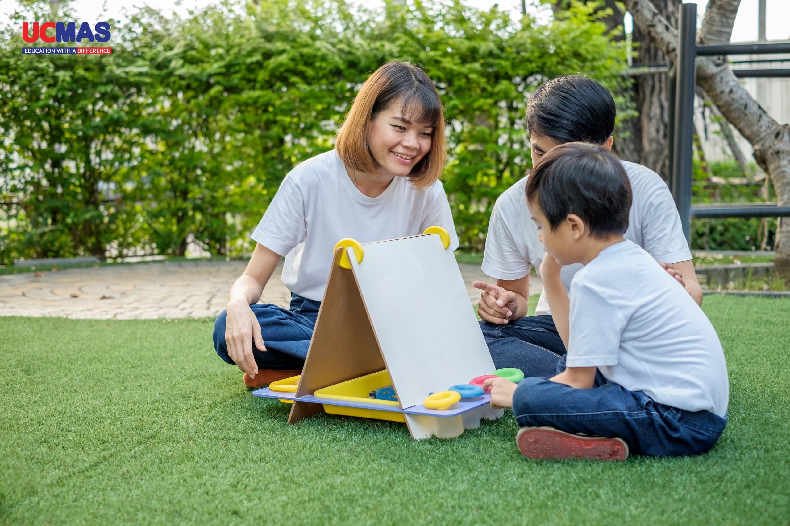 Asian family father mother and son playing with a chalkboard in
